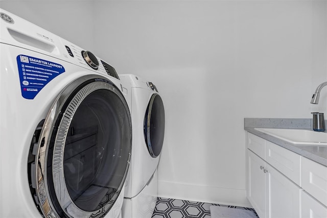 laundry area with cabinets, separate washer and dryer, and sink