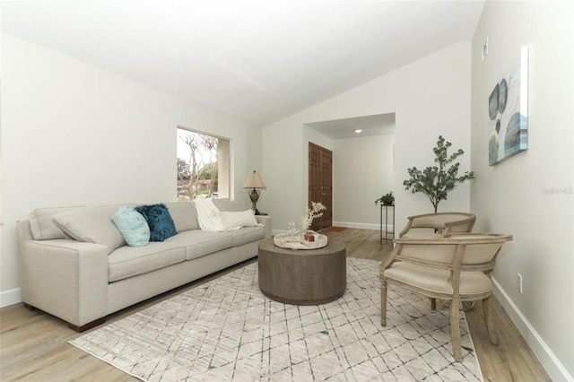 living room featuring lofted ceiling and light wood-type flooring