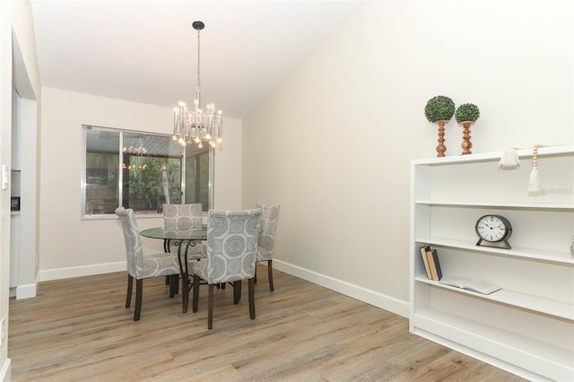 dining area with a notable chandelier and light hardwood / wood-style floors