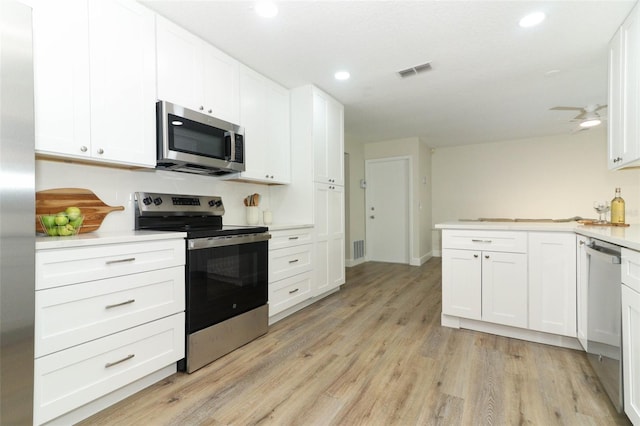 kitchen featuring stainless steel appliances, white cabinets, and light hardwood / wood-style floors