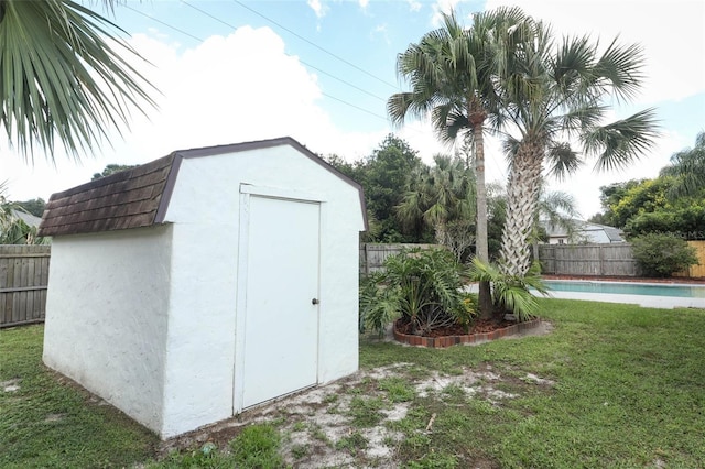 view of outbuilding featuring a yard and a fenced in pool