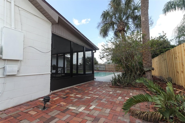 view of patio / terrace featuring a fenced in pool and a sunroom