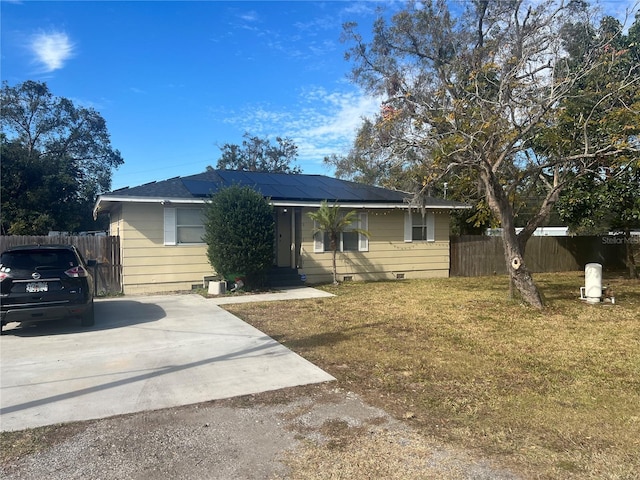 view of front of house featuring a front lawn and solar panels