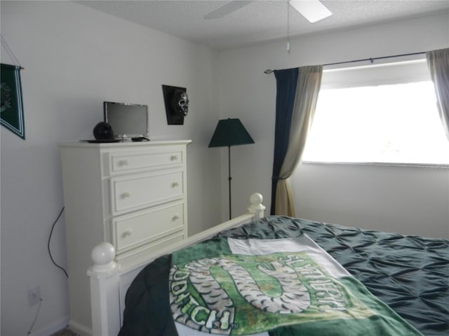 bedroom with ceiling fan and a textured ceiling