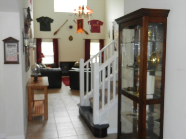 stairs featuring tile patterned flooring and a notable chandelier