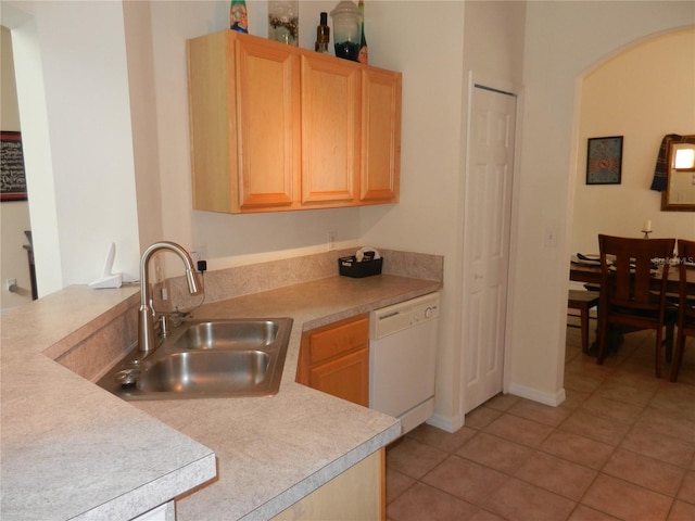 kitchen with sink, white dishwasher, light tile patterned flooring, and light brown cabinetry