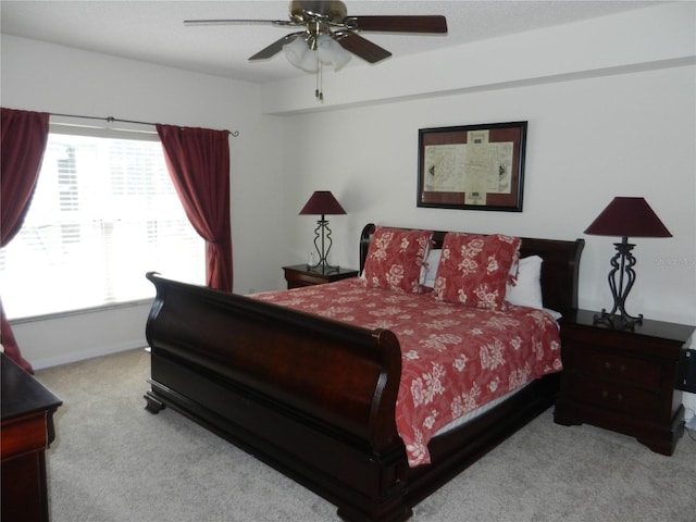 bedroom with multiple windows, light carpet, and ceiling fan