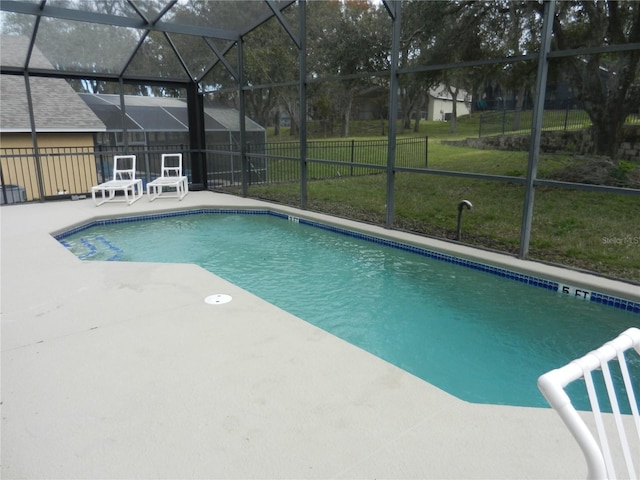 view of swimming pool with a patio area, glass enclosure, and a yard