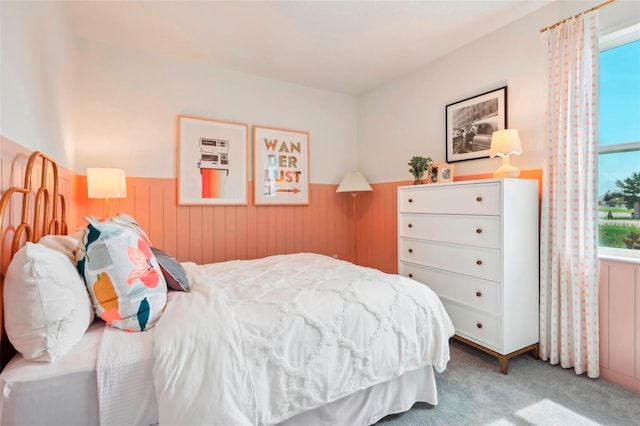 bedroom with carpet floors and wooden walls