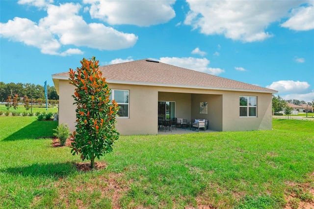 back of property with a yard and a patio area