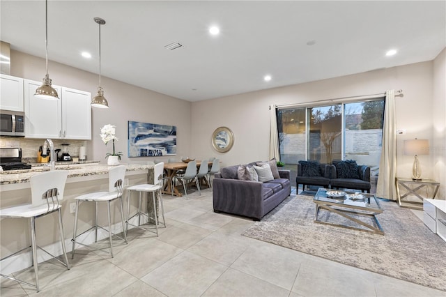 living room featuring sink and light tile patterned floors