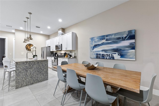 tiled dining room featuring sink