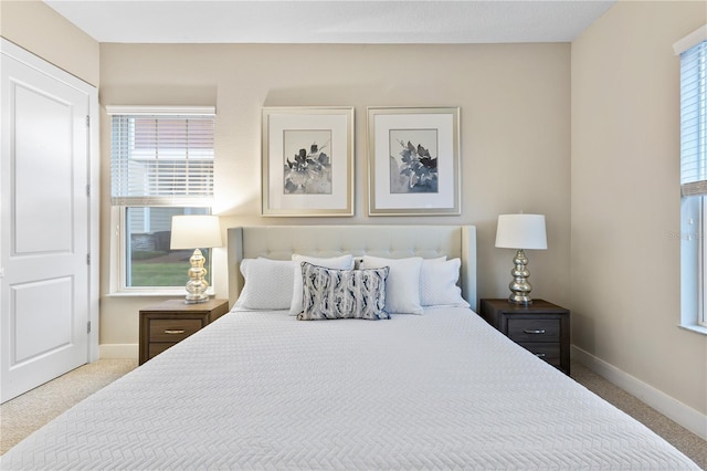 bedroom with multiple windows and light carpet