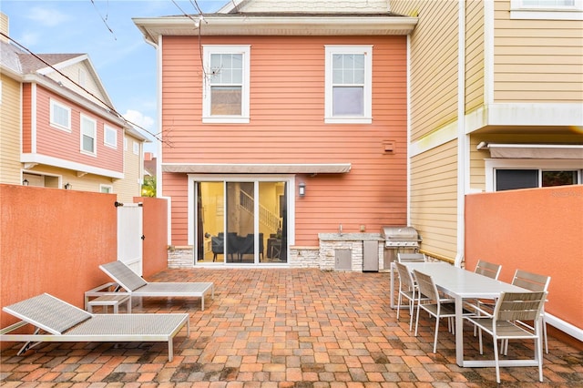 rear view of property featuring a patio and area for grilling