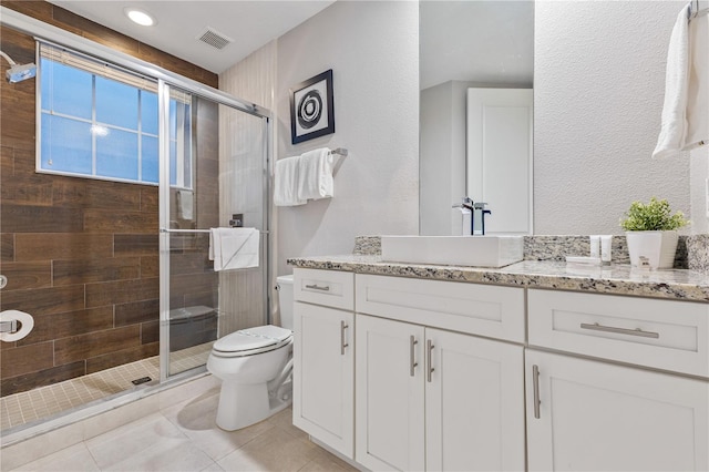 bathroom with vanity, toilet, tile patterned floors, and a shower with shower door