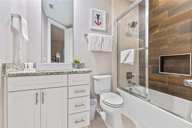 full bathroom with tile patterned floors, vanity, toilet, and combined bath / shower with glass door