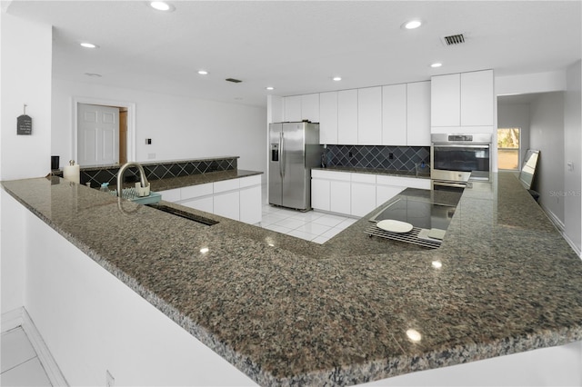 kitchen with stainless steel appliances, white cabinets, sink, and kitchen peninsula