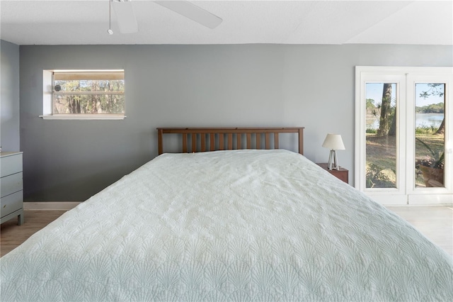 bedroom with wood-type flooring, multiple windows, and ceiling fan