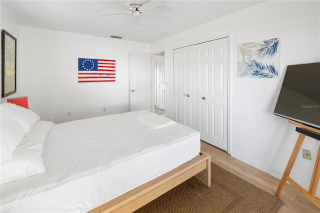 bedroom with ceiling fan, a closet, and hardwood / wood-style flooring