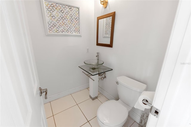 bathroom featuring toilet, tile patterned floors, and sink