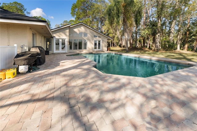 view of swimming pool featuring a patio and french doors