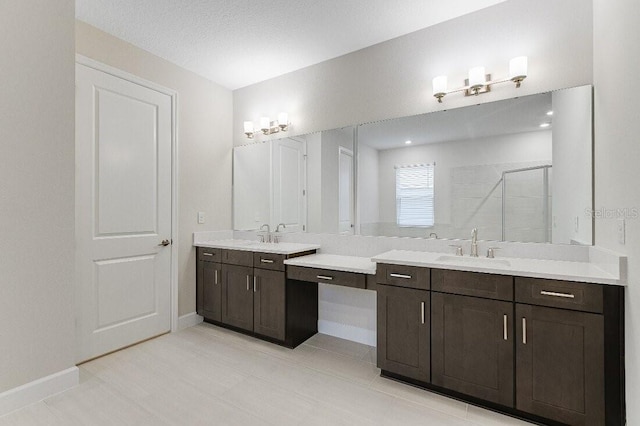 bathroom with vanity, an enclosed shower, and a textured ceiling