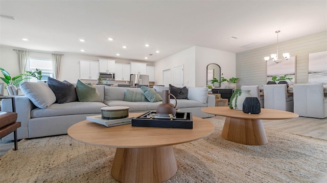 living room featuring an inviting chandelier and light wood-type flooring