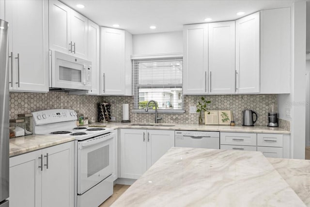 kitchen featuring sink, white cabinets, and white appliances