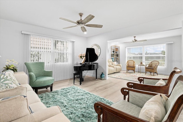 living room with ceiling fan and light hardwood / wood-style flooring