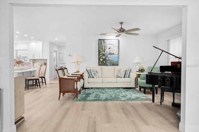 living room with light hardwood / wood-style floors and ceiling fan