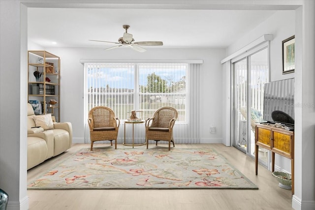 living area featuring ceiling fan and light hardwood / wood-style flooring