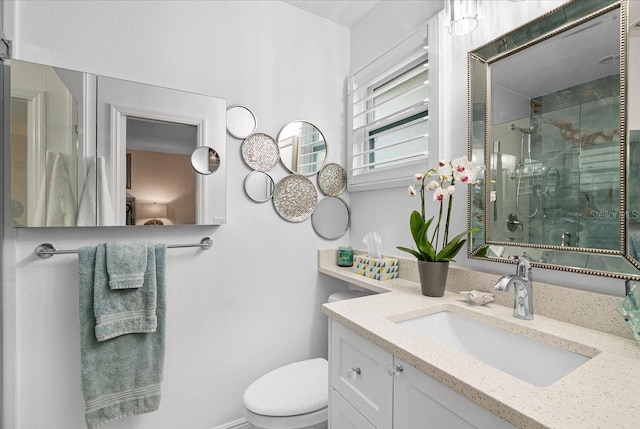 bathroom featuring an enclosed shower, vanity, and toilet