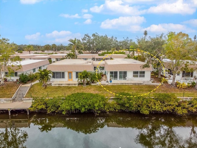 rear view of house featuring a water view and a yard