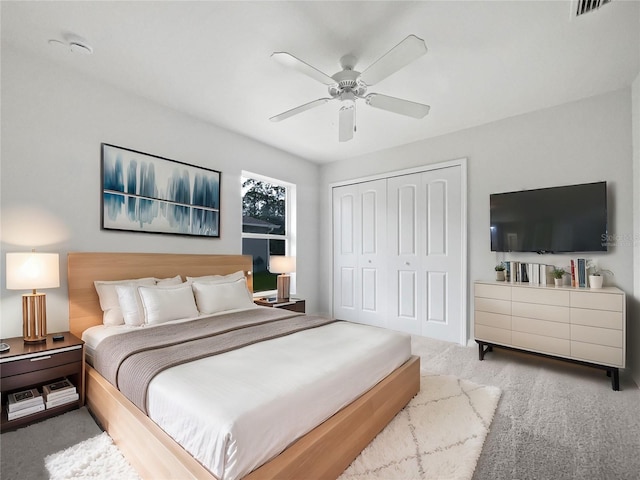 carpeted bedroom with ceiling fan and a closet