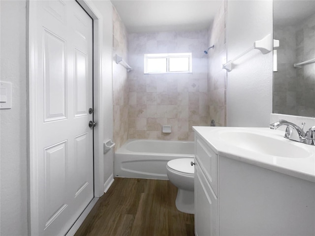 full bathroom with tiled shower / bath combo, toilet, vanity, and wood-type flooring