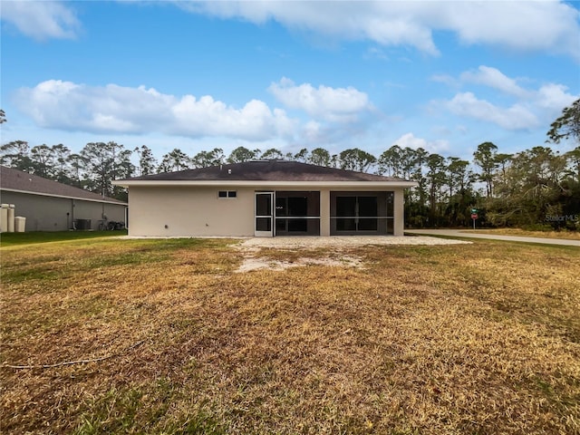 back of property featuring central AC, a sunroom, and a lawn