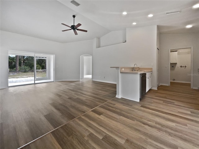 unfurnished living room with sink, dark wood-type flooring, vaulted ceiling, and ceiling fan