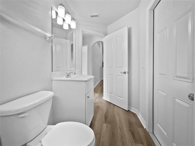 bathroom featuring toilet, vanity, and hardwood / wood-style floors