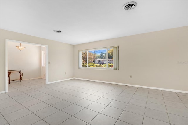 spare room with light tile patterned floors, visible vents, and baseboards