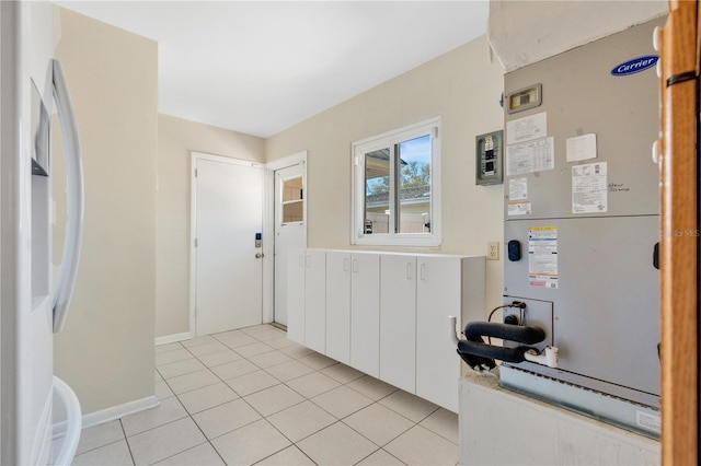 foyer entrance featuring heating unit, light tile patterned floors, and baseboards