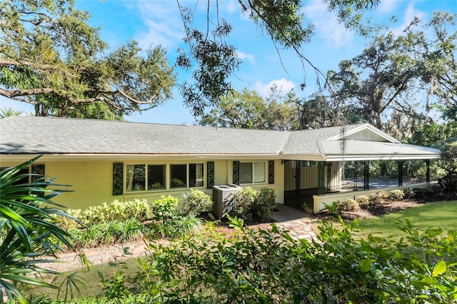 ranch-style house featuring central air condition unit and a carport