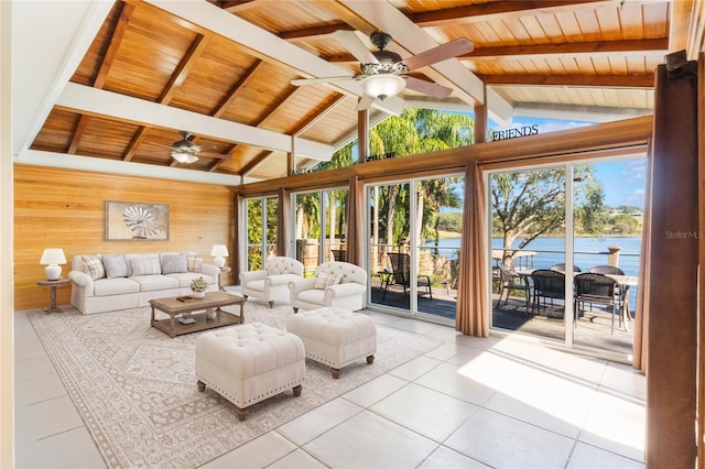 living room with wood ceiling, beam ceiling, a water view, light tile patterned flooring, and wood walls