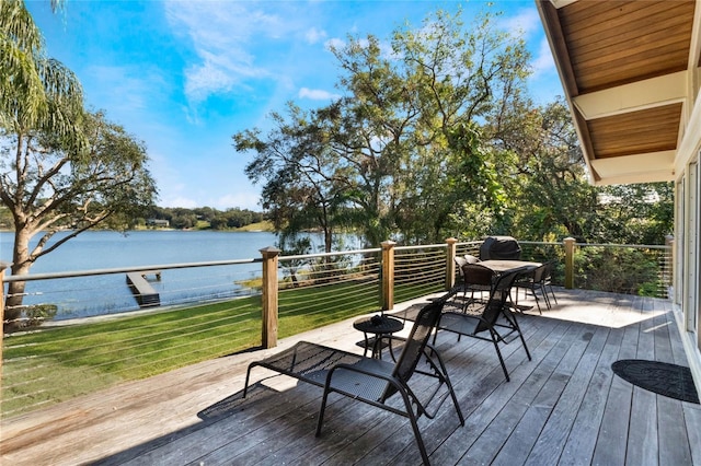 wooden terrace featuring a lawn and a water view