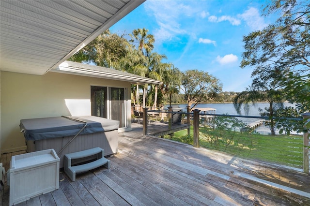 wooden terrace featuring a water view and a hot tub