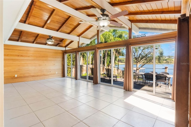 tiled empty room with a water view, plenty of natural light, wood walls, and wooden ceiling