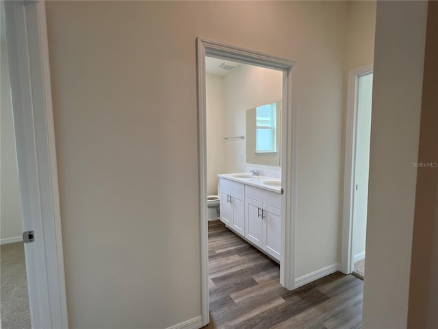 bathroom with hardwood / wood-style flooring, vanity, and toilet