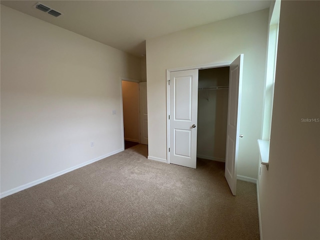 unfurnished bedroom with carpet flooring and a closet