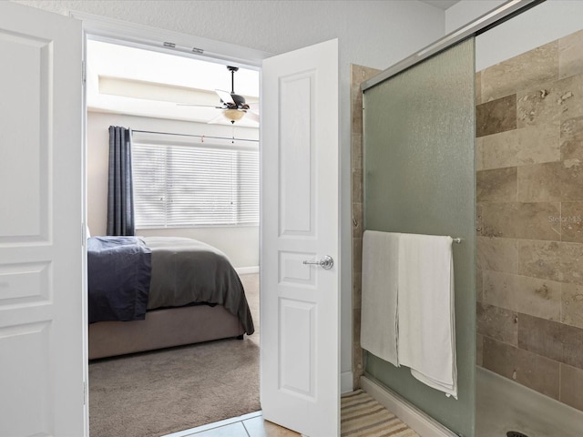 bathroom featuring ceiling fan and a shower with door