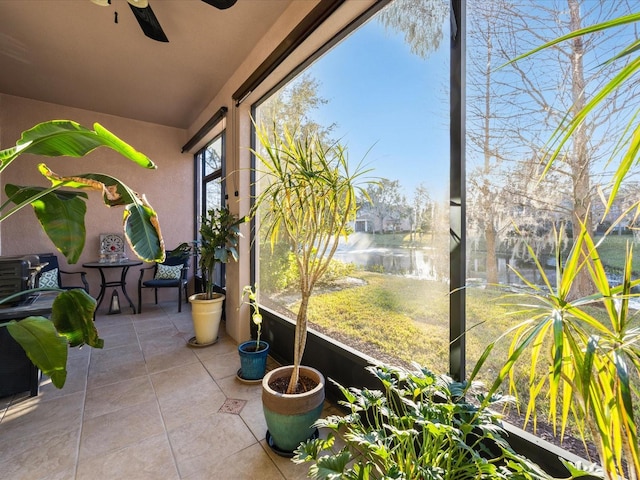 sunroom / solarium featuring a water view and ceiling fan