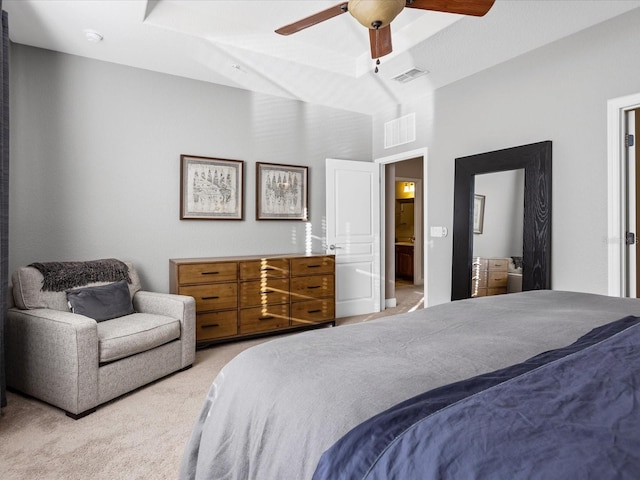 carpeted bedroom with ensuite bath and ceiling fan